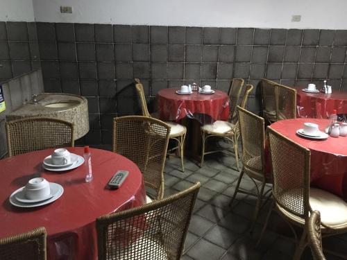 uma sala de jantar com mesas e cadeiras vermelhas em Hotel Santa Inez em Nazaré