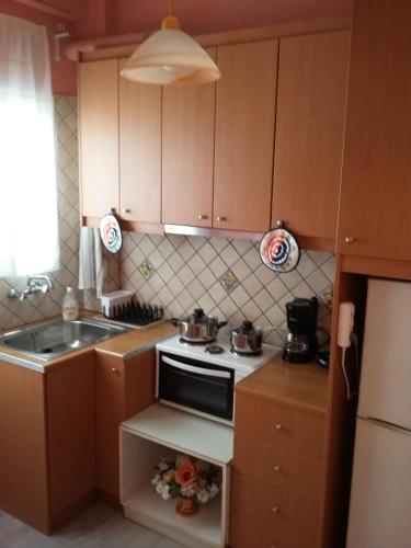 a small kitchen with a stove and a sink at Apartment Michalis by the Sea in Artemida