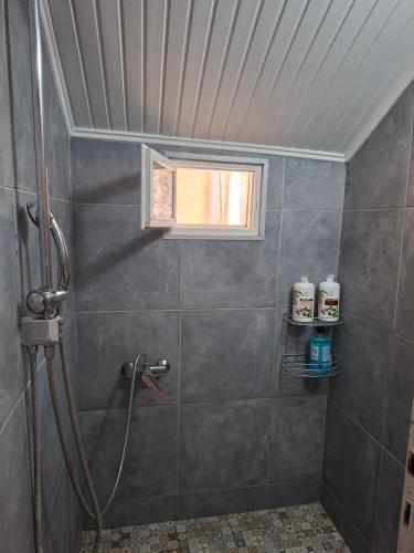 a bathroom with a shower with a window and a shower at Home Maro in Lefkimmi