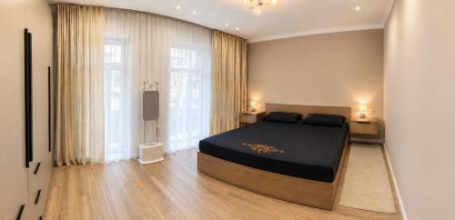 a bedroom with a large bed and a television at РАДУГА Иссык-Куль in Chon-Sary-Oy