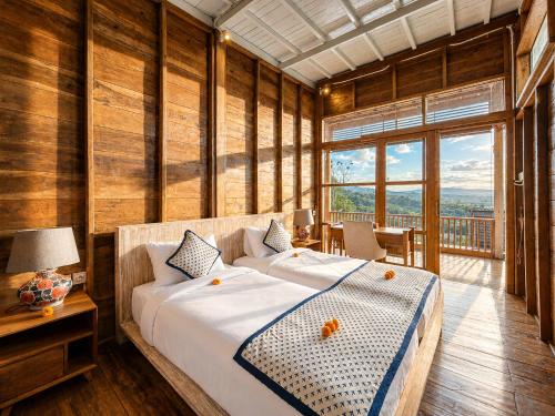 a bedroom with a large bed and a balcony at Mountain Healing Villa by Nagisa Bali in Baturiti
