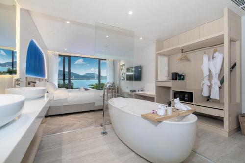 a large white bathroom with two sinks and a tub at IndoChine Resort and Villas in Patong Beach
