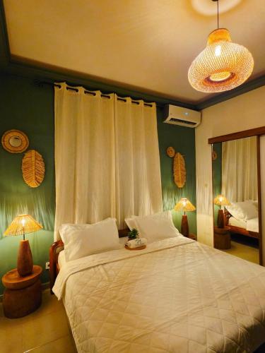 a bedroom with a large white bed with two lamps at Little Heaven Villa in Lomé