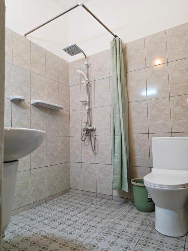 a bathroom with a toilet and a shower and a sink at Little Heaven Villa in Lomé