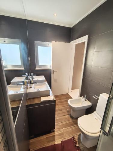 a bathroom with two sinks and a toilet at Beach Hub in São Martinho do Porto