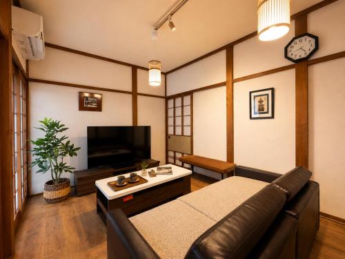 a living room with a couch and a tv at Private House HidaTakayama - Cozy Family Home in Takayama