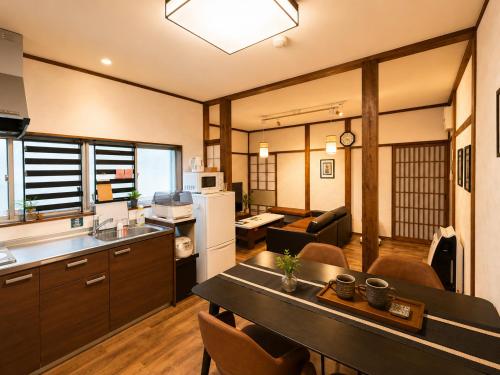 a kitchen and living room with a table in a room at Private House HidaTakayama - Cozy Family Home in Takayama