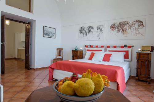 a bedroom with a bed and a bowl of fruit on a table at Starhost - CASA BETTINA enchanting seaview in Vietri sul Mare