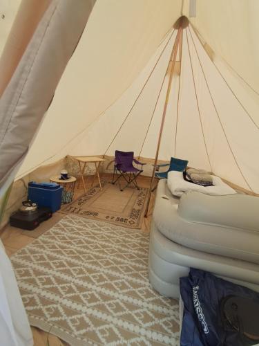a room with a tent with a bed and a rug at Maisie's Campsite in Bideford