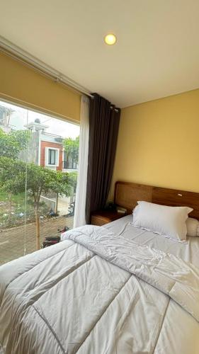 a bed in a bedroom with a large window at Villa Alibaba E5 in Tlekung