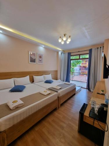 a large bedroom with two beds and a window at Beehive El Nido in El Nido