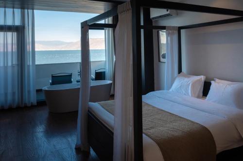 a bedroom with a bed and a bath tub and a window at Anye Seaview Hotel Dali in Dali