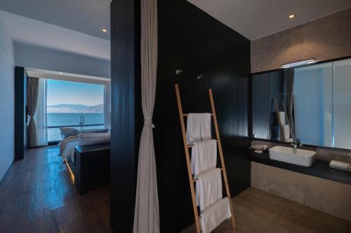 a bathroom with a bed and a sink and a mirror at Anye Seaview Hotel Dali in Dali