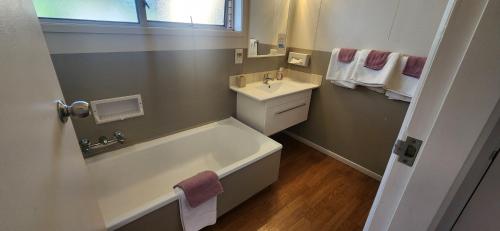 a bathroom with a bath tub and a sink at Aalton Motel in Christchurch