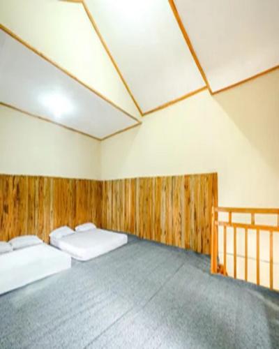 a room with two beds in it with wooden walls at Cozzy Villa RB in Citere