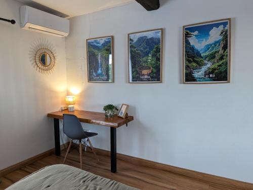 a room with a desk with a chair and pictures on the wall at L'Appart Vanille in Bras-Panon