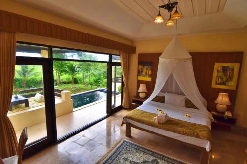 a bedroom with a bed with a canopy at Villa Khao Phaengma in Wang Nam Khieo