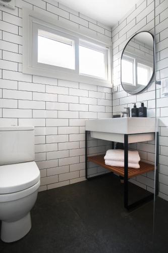a bathroom with a sink and a toilet and a mirror at Cedar Lodge in Braidwood