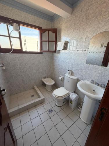 a bathroom with a toilet and a sink at Altos de Belgrano Suites in Tarija
