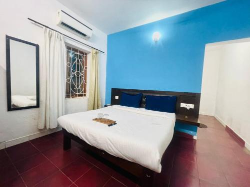 a bedroom with a large bed with a blue wall at Hotel White Sand Bache Stay in Aguada
