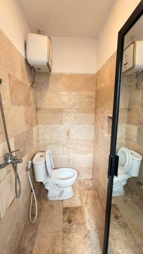 a bathroom with a toilet and a shower at Villa Alibaba D3 in Batu