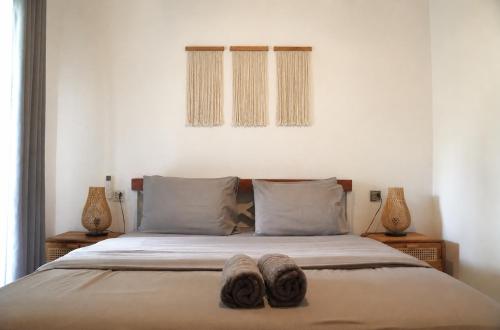 a bed with two pairs of slippers on it at Tipsea Turtle Gili Trawangan in Gili Trawangan