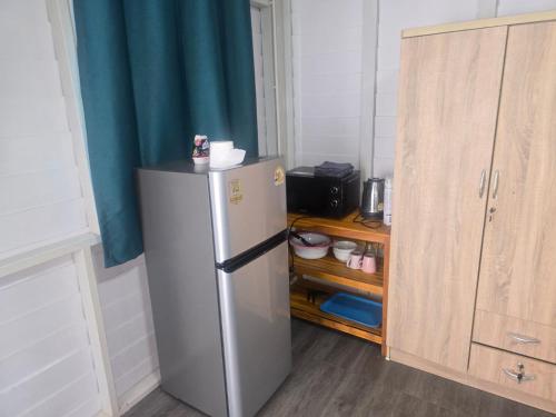 a refrigerator in a kitchen next to a cabinet at sabai resort in Pattaya South