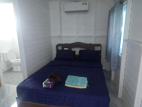 a bedroom with a bed with blue sheets and a toilet at sabai resort in Pattaya South