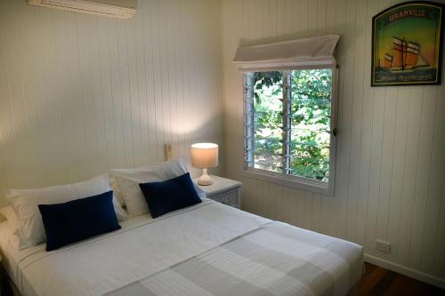a bedroom with a large white bed with a window at Seasons at South Mission Beach in South Mission Beach