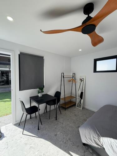 a bedroom with a tv and a table and chairs at Sydney Studio with Private Bathroom & Kitchen in Revesby
