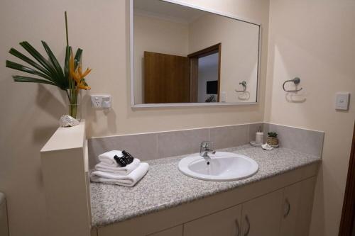 a bathroom with a sink and a mirror at Latitude 17 Suite 2 in South Mission Beach