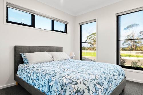a bedroom with a bed and two windows at Pembrey Loop Cowes in Cowes