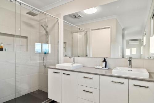 a white bathroom with two sinks and a shower at Pembrey Loop Cowes in Cowes