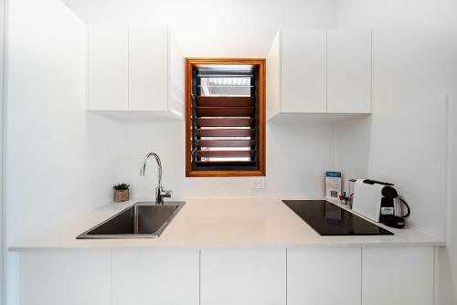 a white kitchen with a sink and a window at Latitude 17 Suite 3 in South Mission Beach