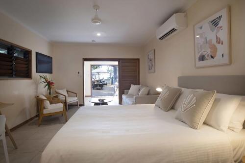 a bedroom with a large white bed and a living room at Latitude 17 Suite 3 in South Mission Beach