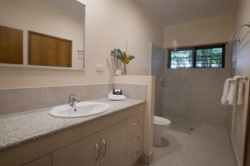 a bathroom with a sink and a toilet and a mirror at Latitude 17 Suite 4 in South Mission Beach