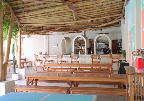 a group of wooden tables and chairs in a restaurant at Tipsea Turtle Gili Trawangan in Gili Trawangan