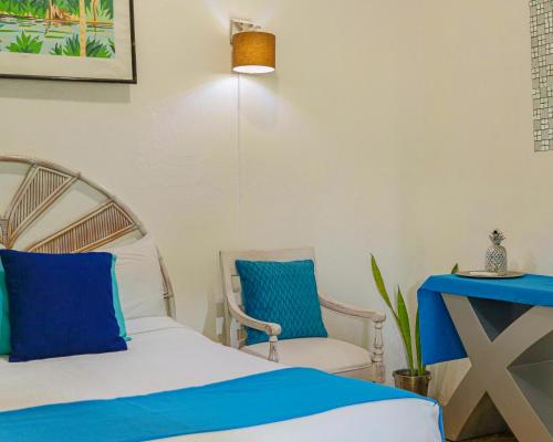 a bedroom with a bed and two chairs at Hotel El Tronco Inc in Boca Chica