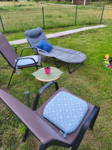 a group of three chairs and a table in a yard at Home Delic Komarnica in Šavnik