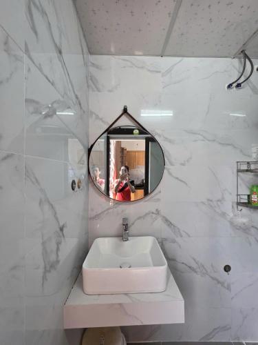 a white bathroom with a sink and a mirror at Lishome My Khe Beach Apartment - An Thuong in Danang
