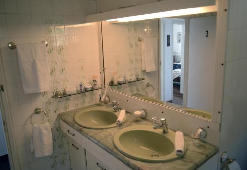 a bathroom with two sinks and a large mirror at Athanasia Villa in Nerátza