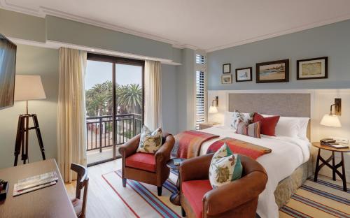 a hotel room with a bed and a balcony at Strand Hotel Swakopmund in Swakopmund