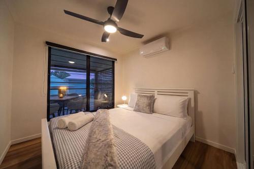 a bedroom with a bed with a ceiling fan at Serenity Sands in South Mission Beach