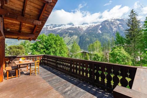 a balcony with a table and a view of mountains at Chalet du Brevent ski in - ski out - Happy Rentals in Chamonix