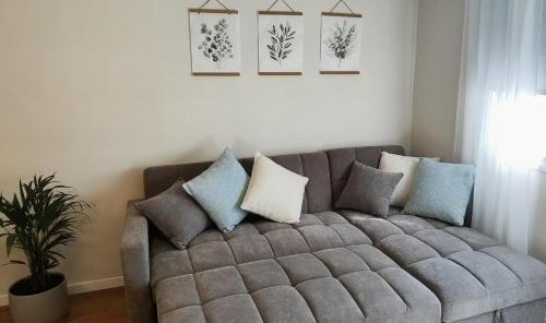 a gray couch in a living room with pillows at פינה בנחלה in Ma'ale Gamla