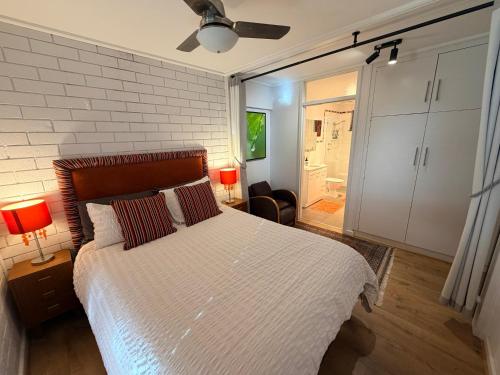 a bedroom with a bed and a white brick wall at Oasis at Aldinga Beach in Aldinga Beach