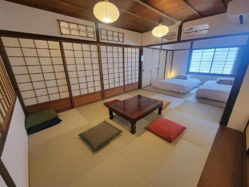 a room with a table and two beds in it at Rinku Base Ichi in Tajiri