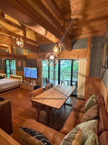a dining room with a table and a couch at 森権太 Forest Gonta in Takamori