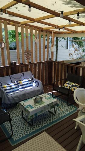 a bed and a table on a deck at Mobil home 3ch, clim, bord de mer in Seignosse