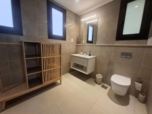 a bathroom with a toilet and a sink at Tulip River View in Ma‘mūrah